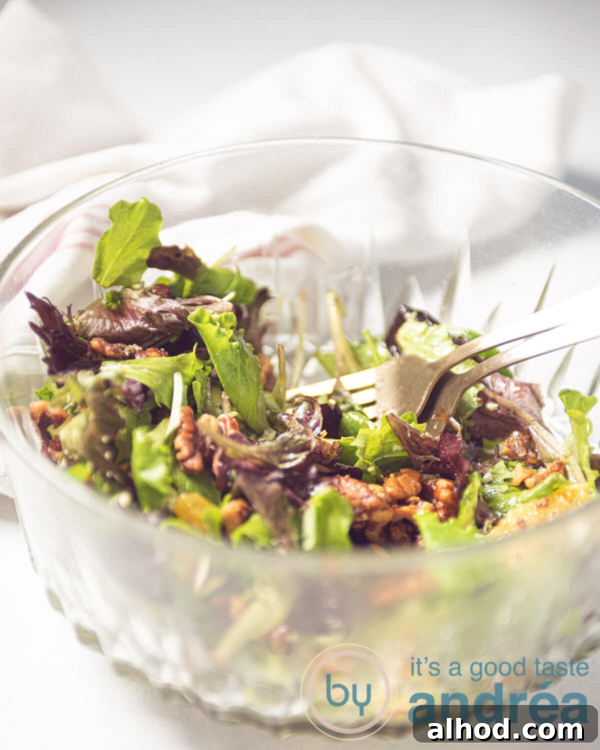 Spicy Blue Cheese Salad with Walnuts and Orange 8 A glass bowl filled with a fresh salad with oranges, candied walnuts, and crumbled blue cheese, ready to be served.