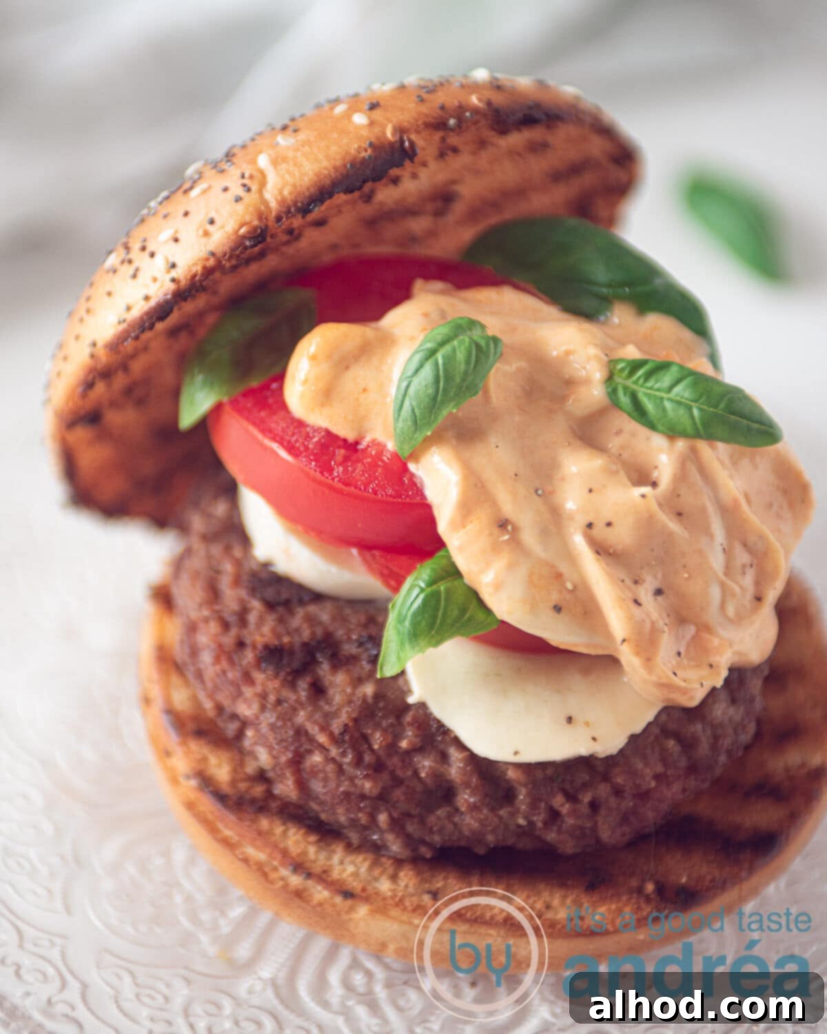 Summer Caprese Burger with Zesty Pesto Aioli 2 A complete Italian Caprese hamburger topped with a burger, mozzarella, and tomatoes, drizzled with pesto mayonnaise, and garnished with fresh basil. Perfect for a summer BBQ.
