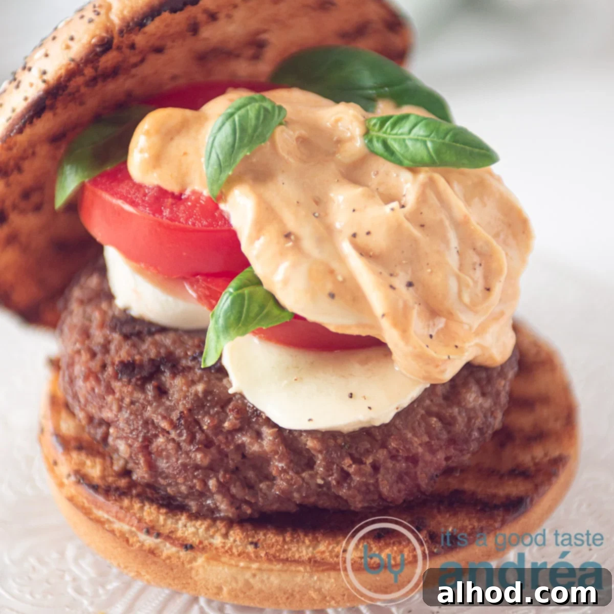 Summer Caprese Burger with Zesty Pesto Aioli 4 A burger on a bun with mozzarella, tomato, and pesto mayonnaise