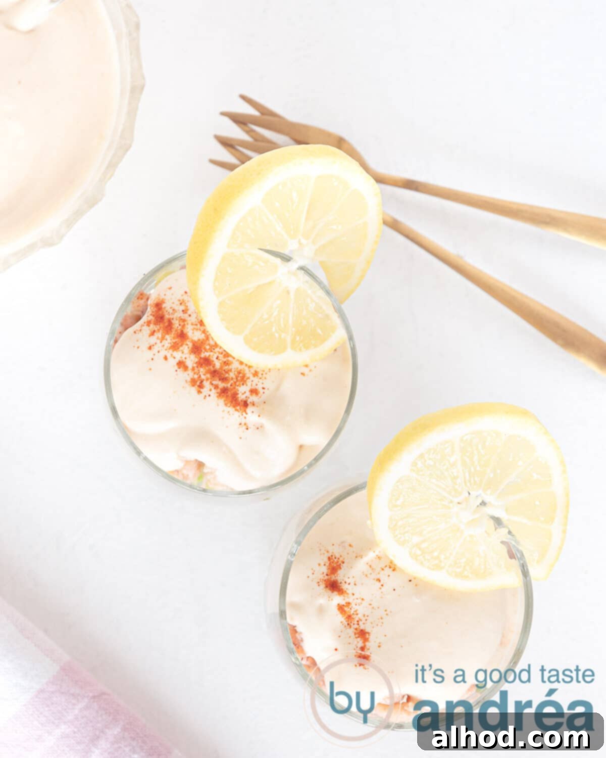 Deluxe Dutch Shrimp Cocktail with Homemade Whiskey Sauce 2 Two elegant glasses filled with Dutch shrimp cocktail, showcasing layers of crispy lettuce, pink shrimp, and creamy whiskey cocktail sauce.