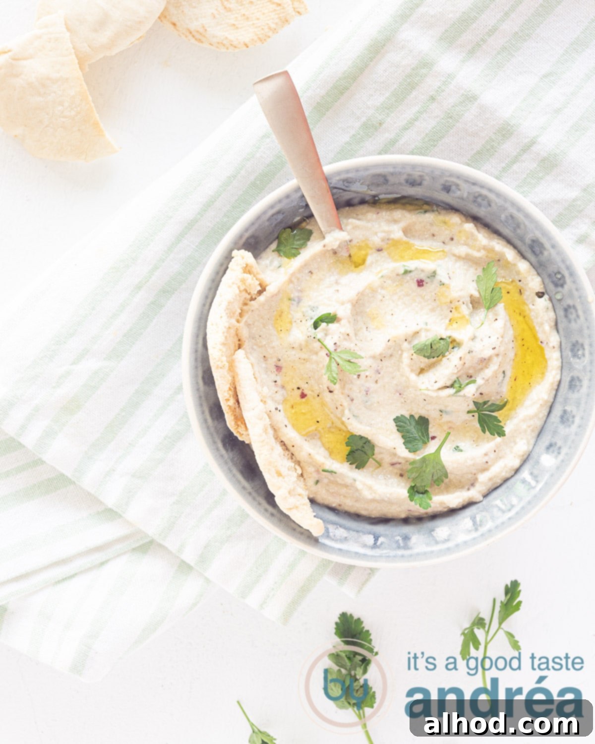 Melitzanosalata: Authentic Greek Roasted Eggplant Dip 2 Top photo of a grey bowl filled with homemade Greek roasted eggplant dip, garnished with parsley.