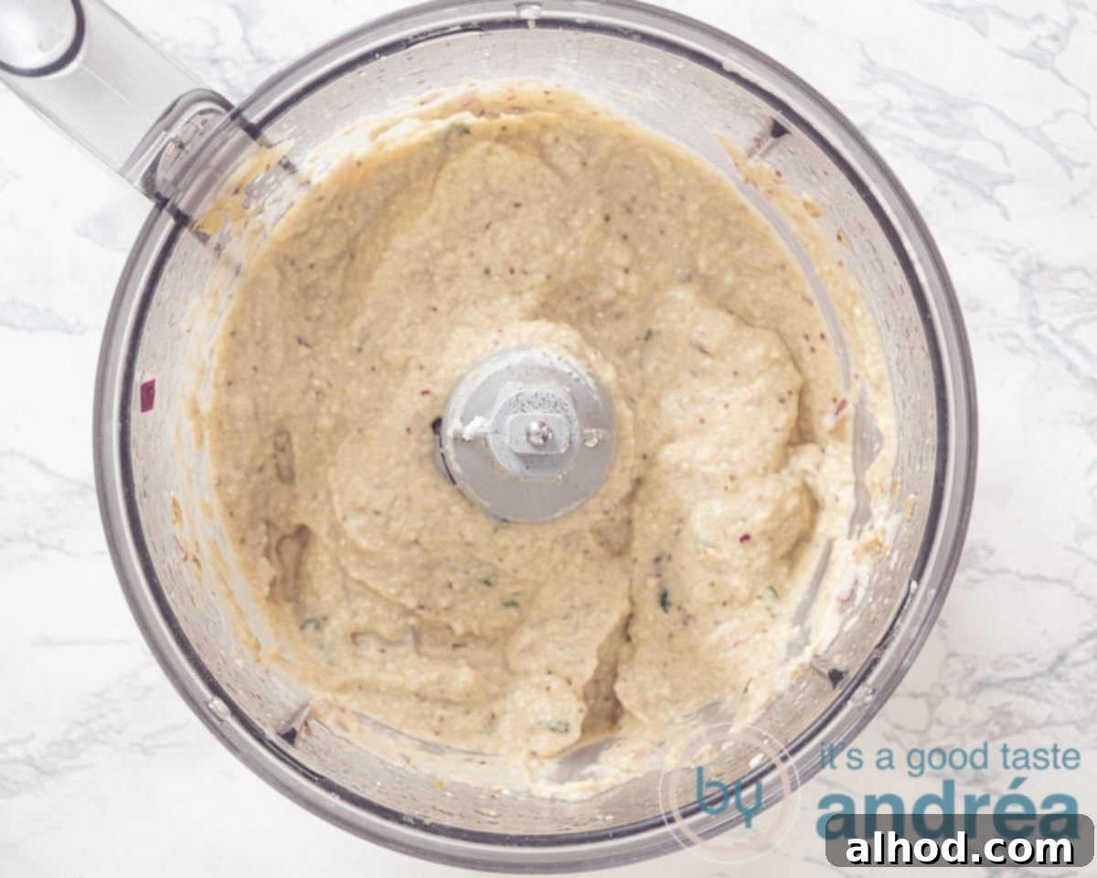 Melitzanosalata: Authentic Greek Roasted Eggplant Dip 5 Bowl of a food processor filled with Melitzanosalata dip ingredients, ready for blending.