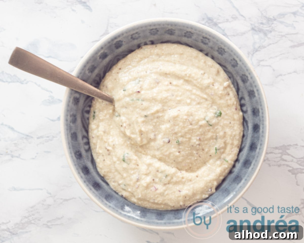 Melitzanosalata: Authentic Greek Roasted Eggplant Dip 6 A bowl of melitzanosalata garnished with a swirl of olive oil and fresh parsley.