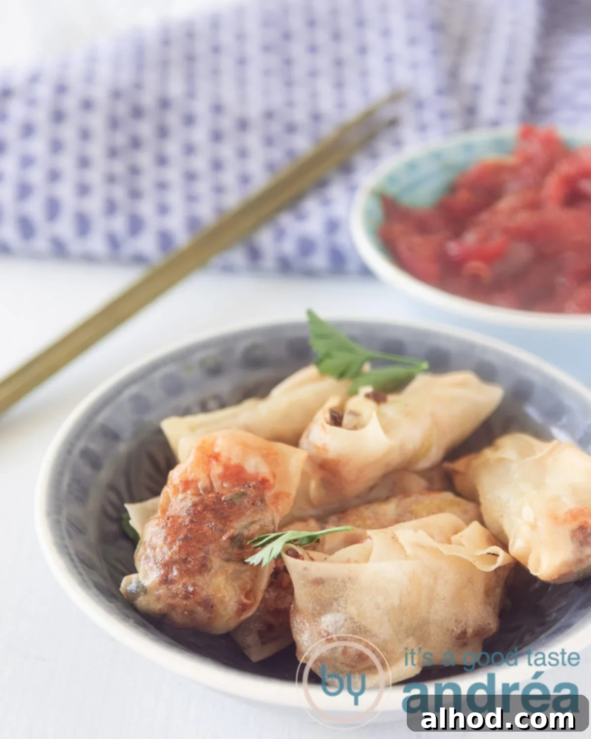 Crispy Air Fryer Indonesian Mini Spring Rolls 2 A bowl with Indonesian mini spring rolls and a bowl with a homemade sauce in the back