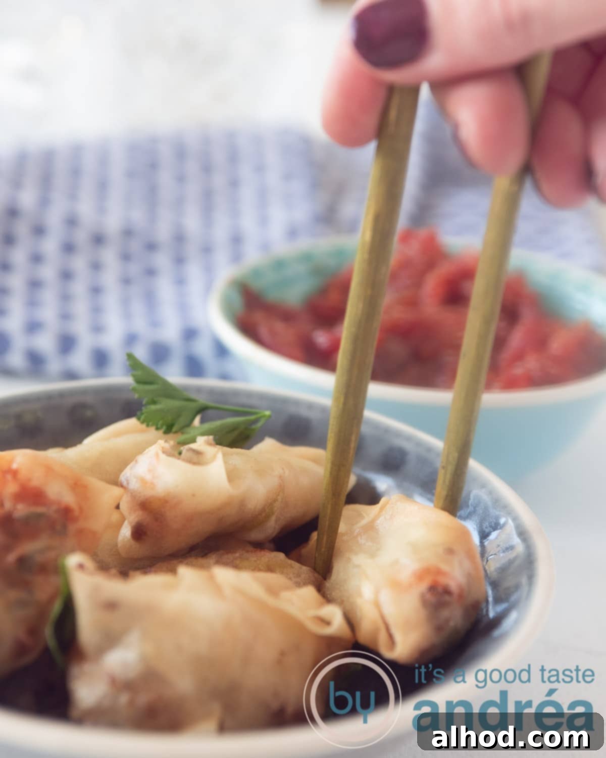 Crispy Air Fryer Indonesian Mini Spring Rolls 11 Some chopsticks taken a mini spring roll. Some sweet and sour tomato sauce in the back