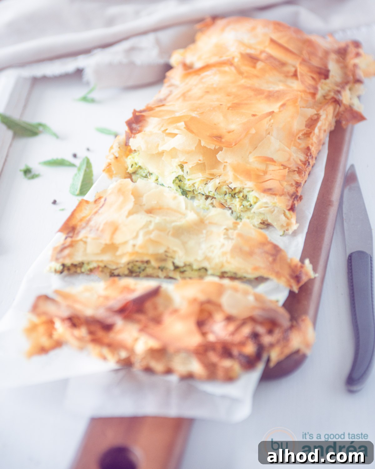 A traditional Kolokithopita, or Greek zucchini quiche, showcasing its golden phyllo crust and a rich, savory filling with feta and herbs.