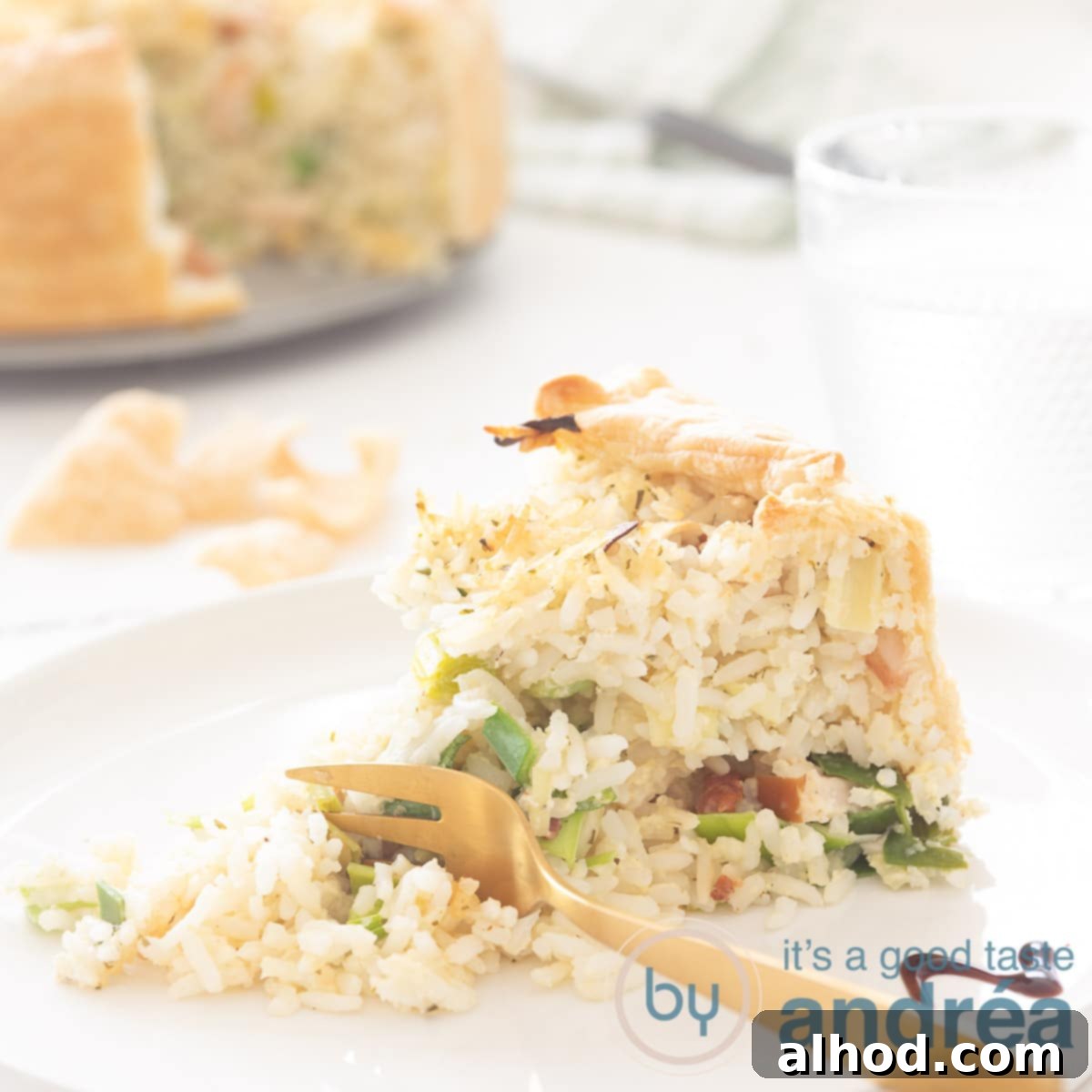 A hearty slice of Chicken Quiche with Leek and Rice, perfectly cooked and showcasing its savory layers, with the rest of the pie blurred in the background.