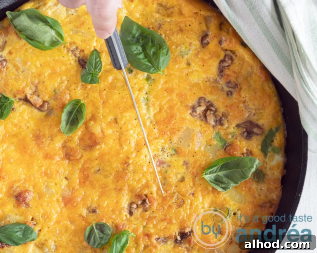 Savory Bacon and Golden Spanish Tortilla Bake 7 A baked tortilla in a cast iron pan. A knife is slicing through the tortilla