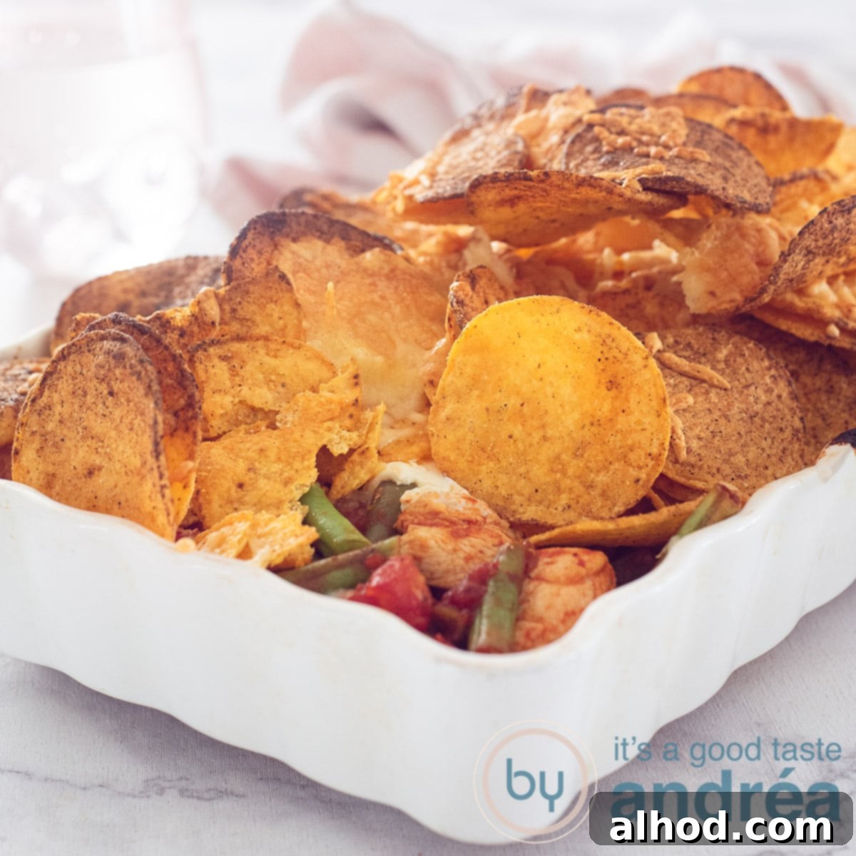 A delicious chicken nacho casserole topped with crispy tortilla chips and melted cheese, ready to serve.