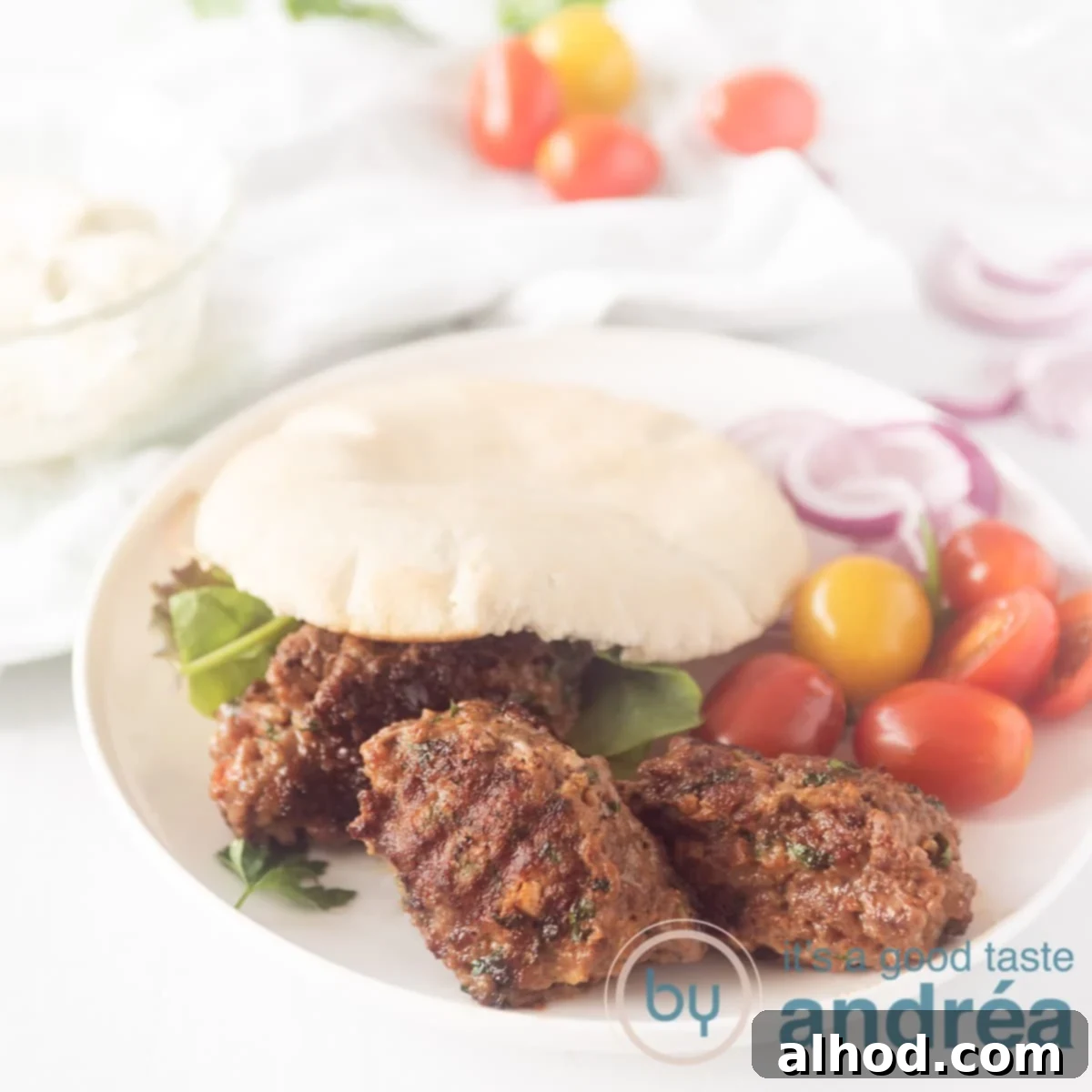 Cevapi: Serbia's Iconic Grilled Sausage 6 square photo with grilled spicy minced meat in a sandwich with tomatoes around it