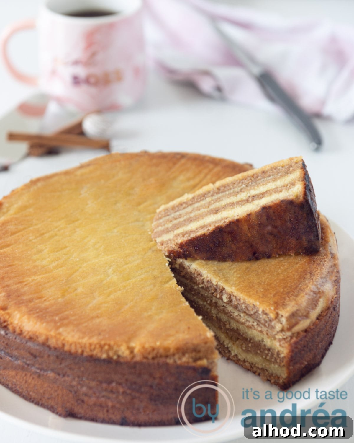 Lapis Legit Thousand Layer Cake 2 A round thousand layers cake. Cut out a part so you can see the layers well and put it on top. A cup of coffee and the knife in the background