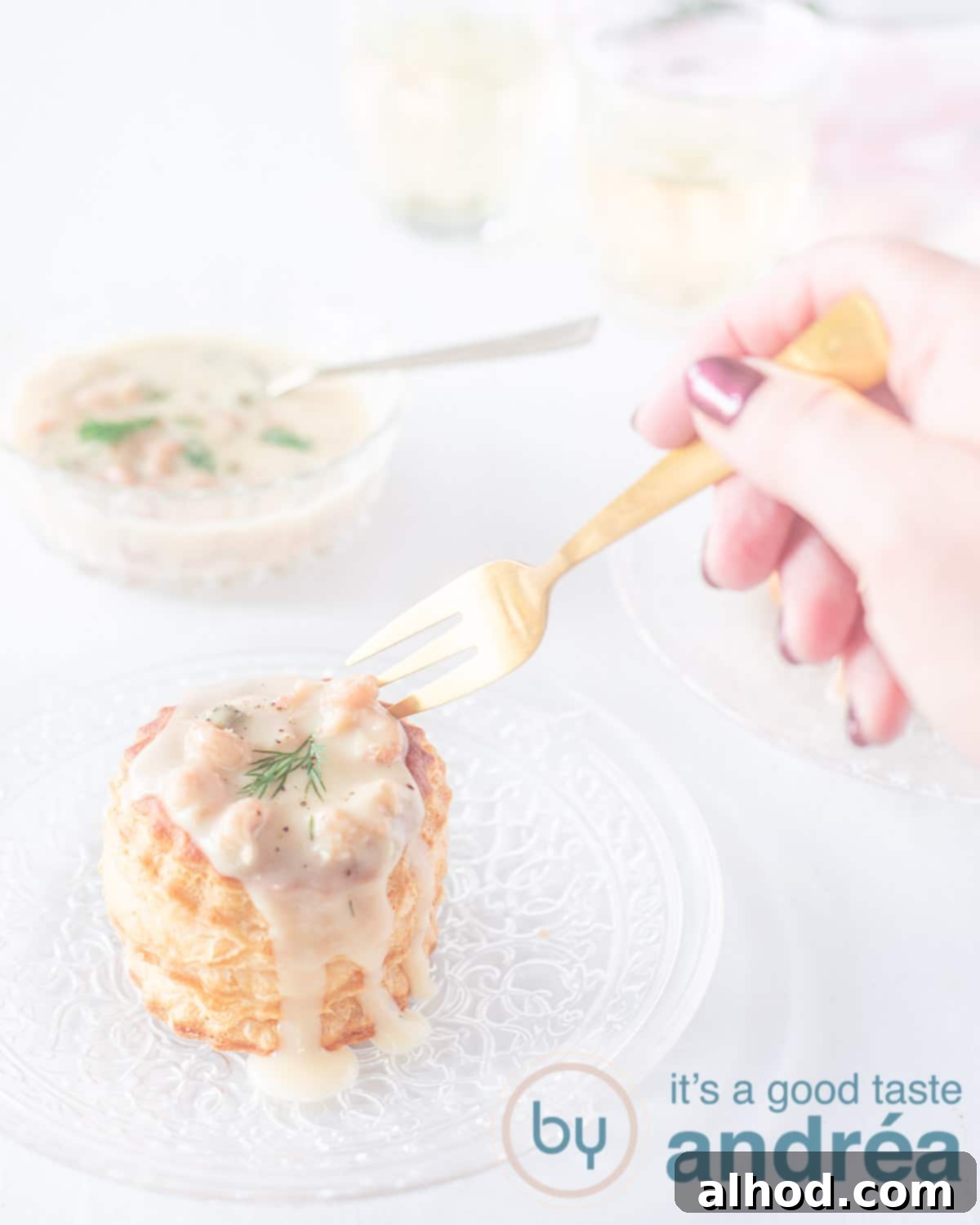 Dutch Shrimp Ragout Puffs 2 A fork taking a bite of garnalenragout from a puff pastry baskets. In the back some more shrimp gravy and white wine