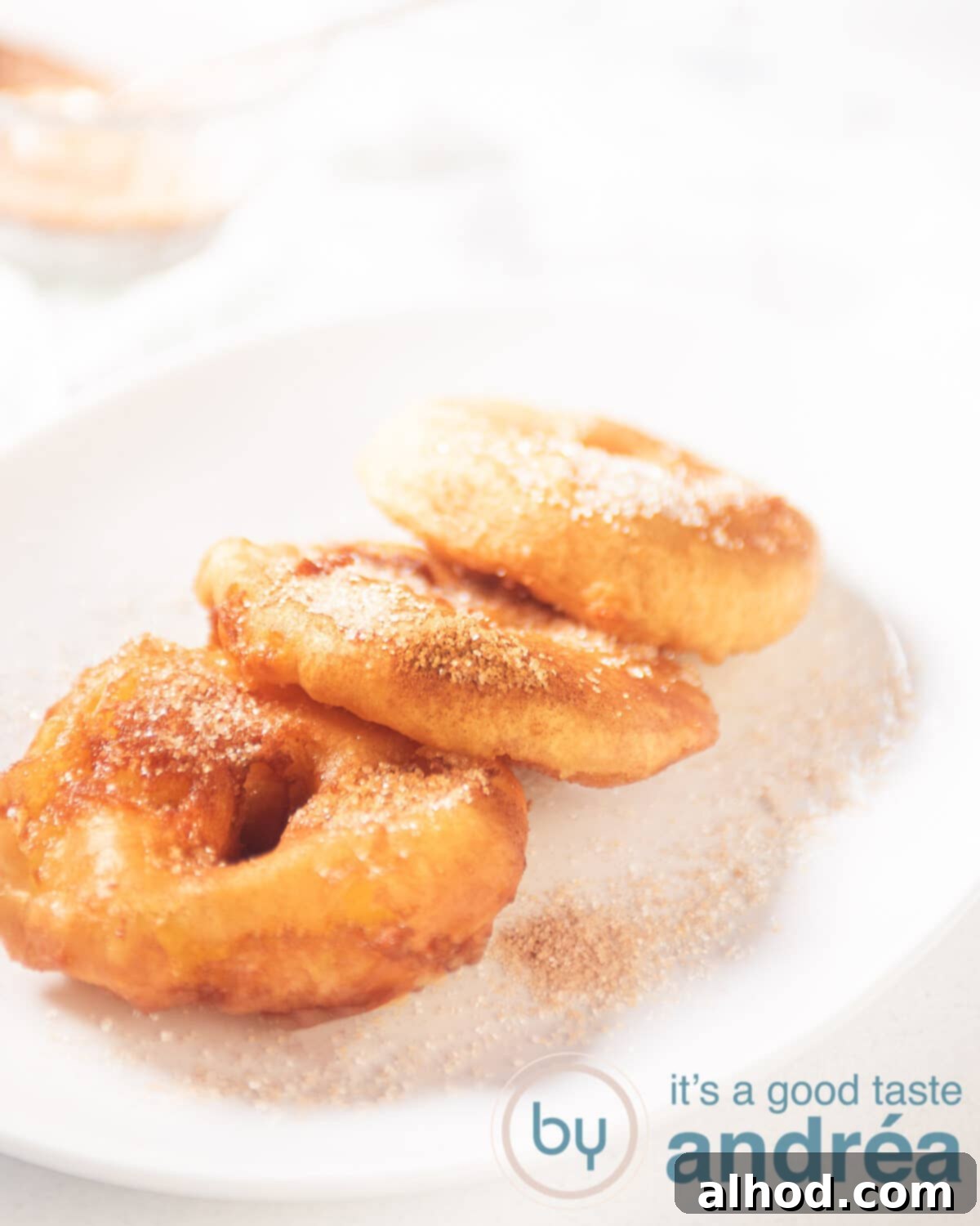 Traditional Dutch Apple Doughnuts 2 A white bowl with three apple fritters