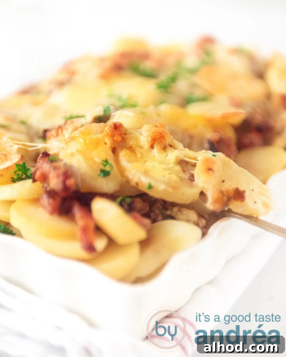 Creamy Dutch Potato and Ground Beef Casserole 5 A spoon takes a bite of potato out of the oven dish differently.