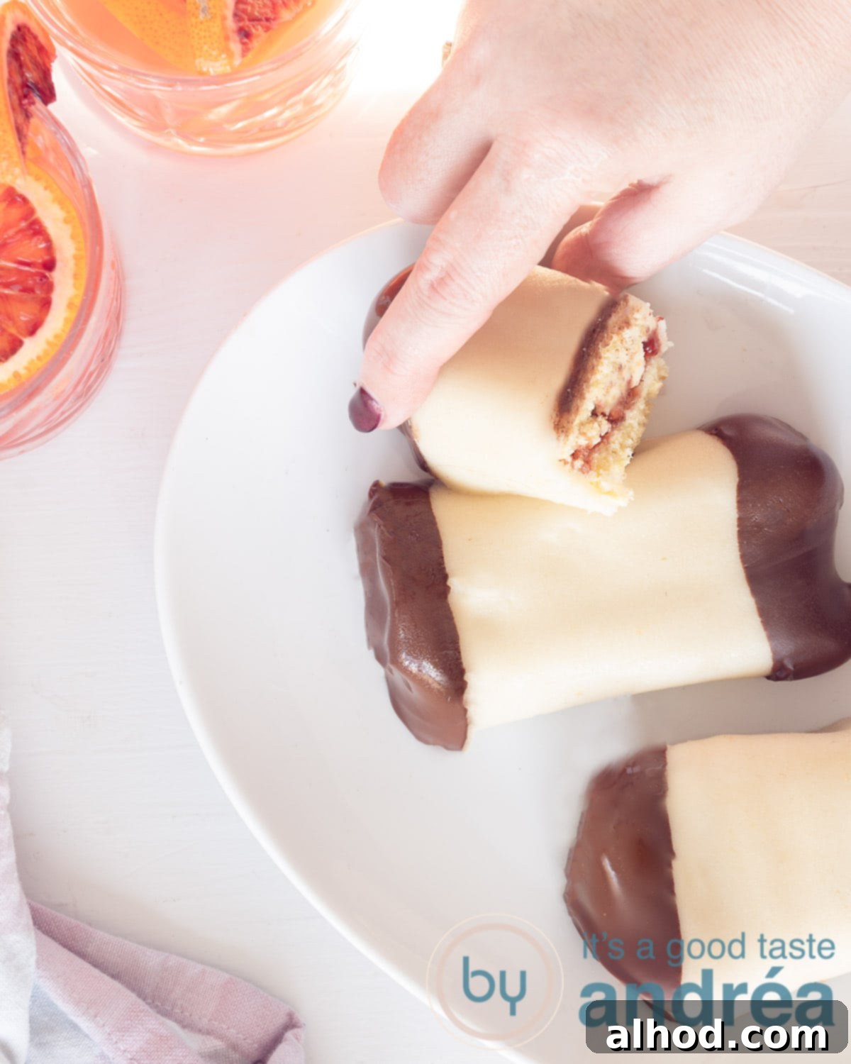 Mergpijpjes Beloved Dutch Marzipan Treats 2 A top-down photo of a cake with marzipan and chocolate coating, filled with jam and cream, on a white background. This image showcases a perfectly made Dutch Mergpijpje, ready to be enjoyed.