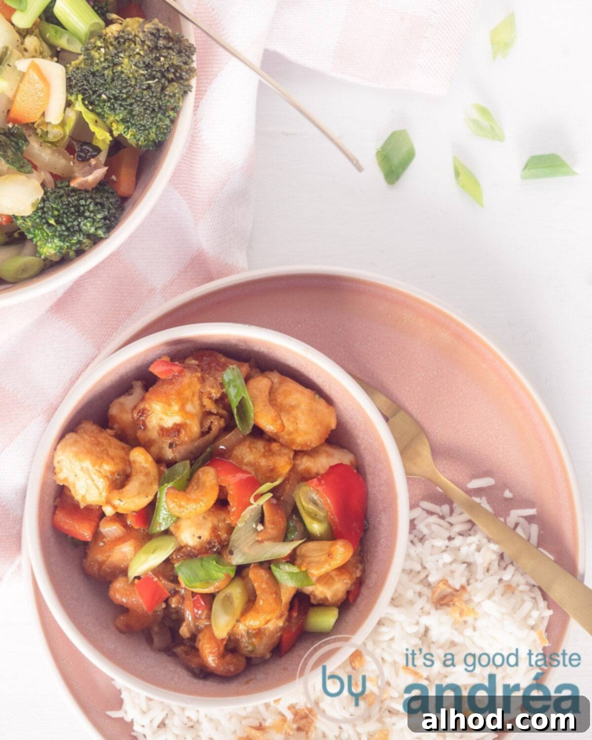 15-Minute Spicy Cashew Chicken 5 A photo from above of Thai chicken in a delicious sauce with bell pepper and spring onions. On a pink plate and that is on a white background