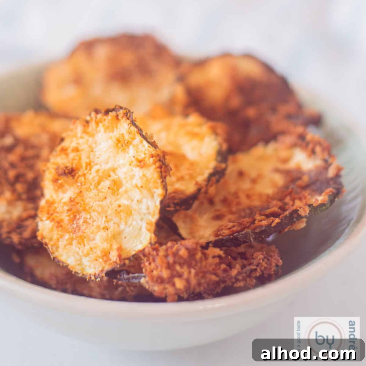 Crispy Air Fryer Zucchini Chips with Parmesan 6 A square picture with a bowl of crispy zucchini chips, perfectly golden brown and ready to eat.