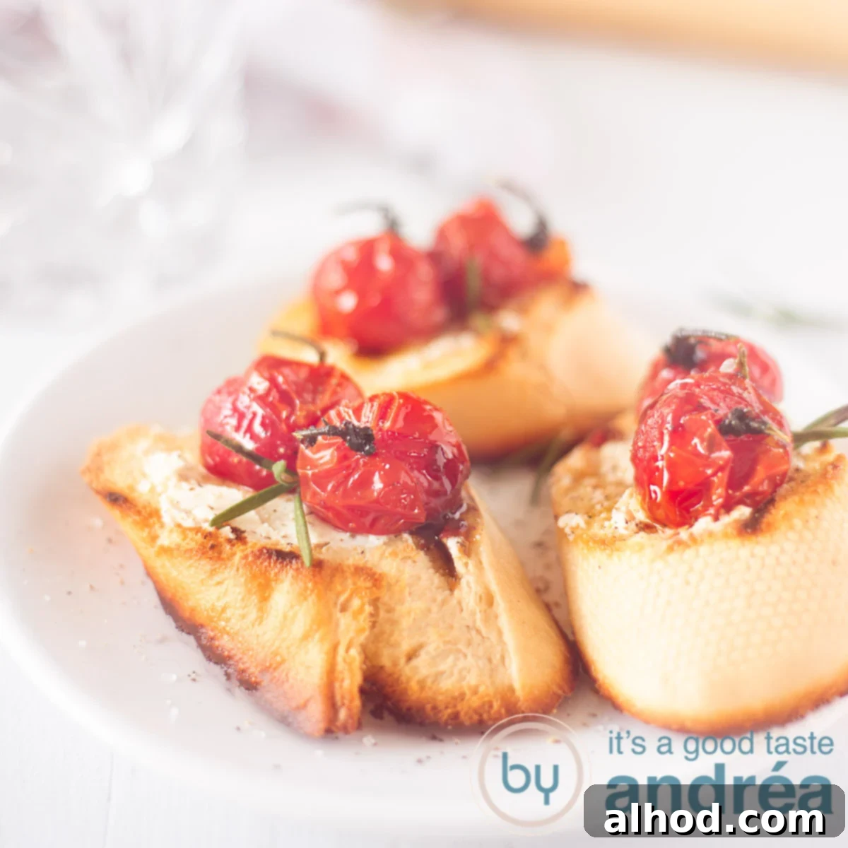 Creamy Goat Cheese and Roasted Tomato Bruschetta 6 A square photo with three bruschetta topped with goat cheese and roasted tomatoes on a white background