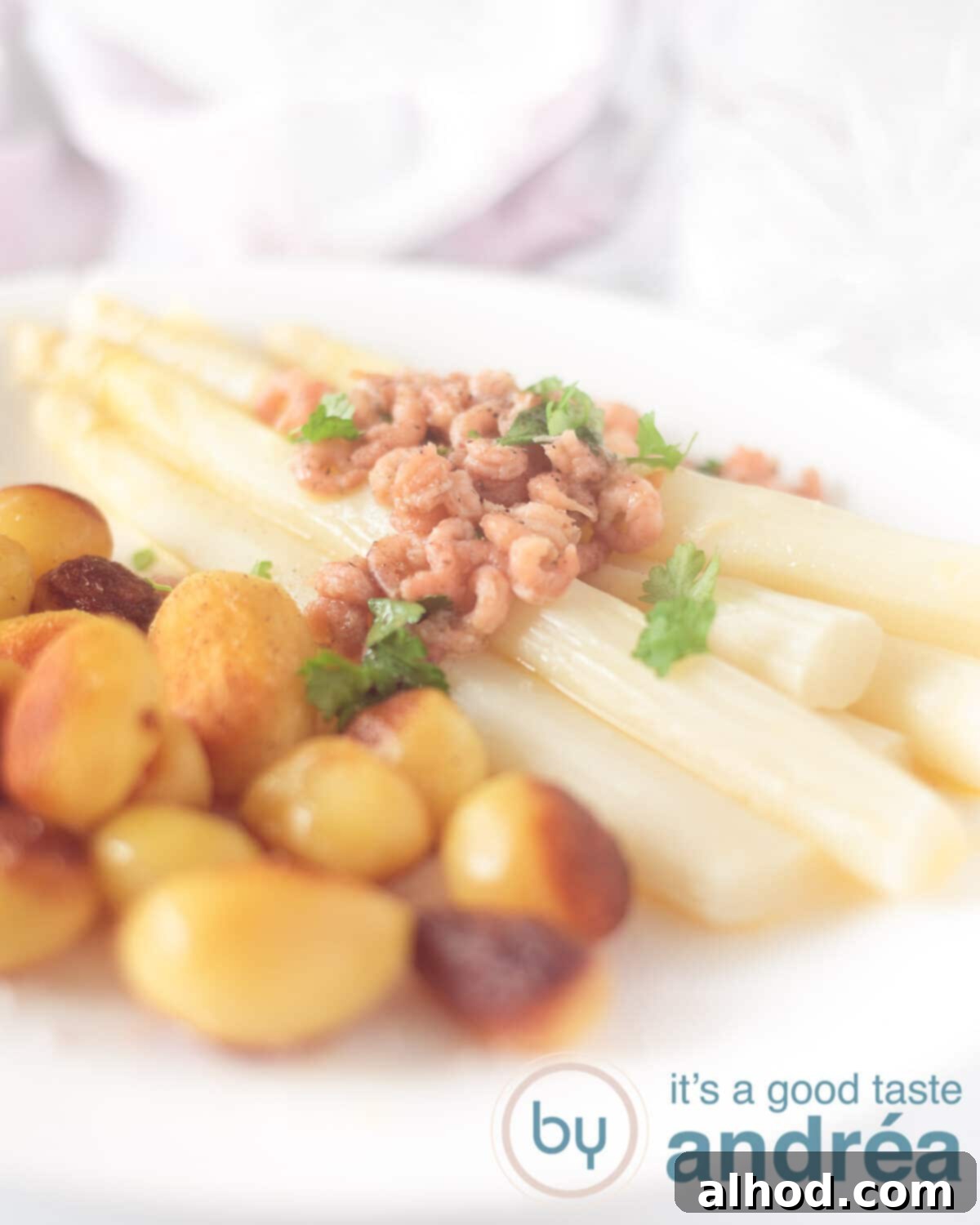 Tender German White Asparagus with Melted Butter 5 An elevation photo with a white board. Baked potatoes on the left, asparagus on the right and a butter shrimp sauce on the asparagus