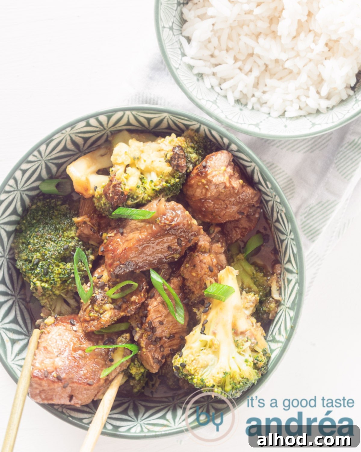 Effortless 20-Minute Teriyaki Beef and Broccoli Dinner 5 A photo from above with a bowl filled with broccoli and steak in teriyaki sauce and a bowl with rice on a white background