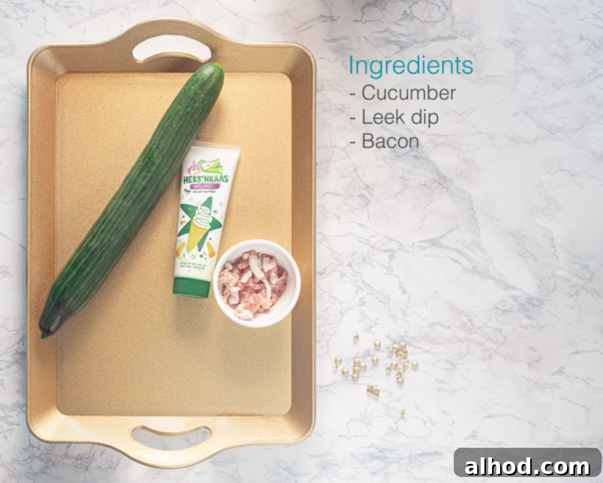 Leek Dip Cucumber Bites with Crispy Bacon 3 Individually labeled ingredients on a golden tray to make cucumber appetizers with leek dip and bacon laid out on a white marble backdrop
