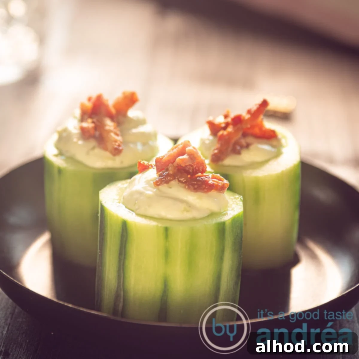 Leek Dip Cucumber Bites with Crispy Bacon 6 a square photo of cucumber bite appetizers on a black plate, with leek dip and bacon