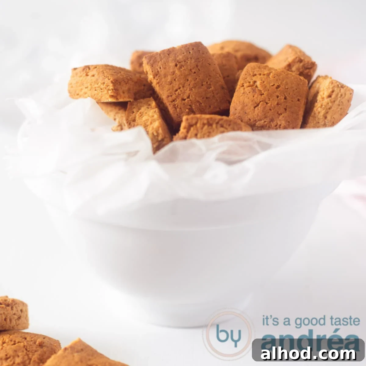 Dutch Pepernoten: Spiced Cookie Delights 6 Een wit bakje met Oud-Hollandse pepernoten in een wit bakpapier op een witte ondergrond