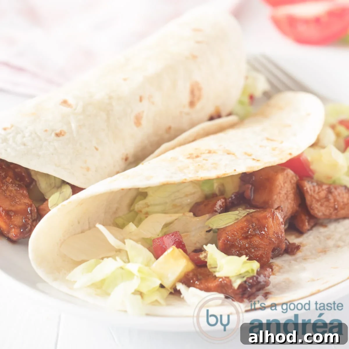 Flavorful Soy Chicken Wraps 6 A square photo with two wraps rolled up, 1 half opened with soy sauce, lettuce, tomato on a white background.