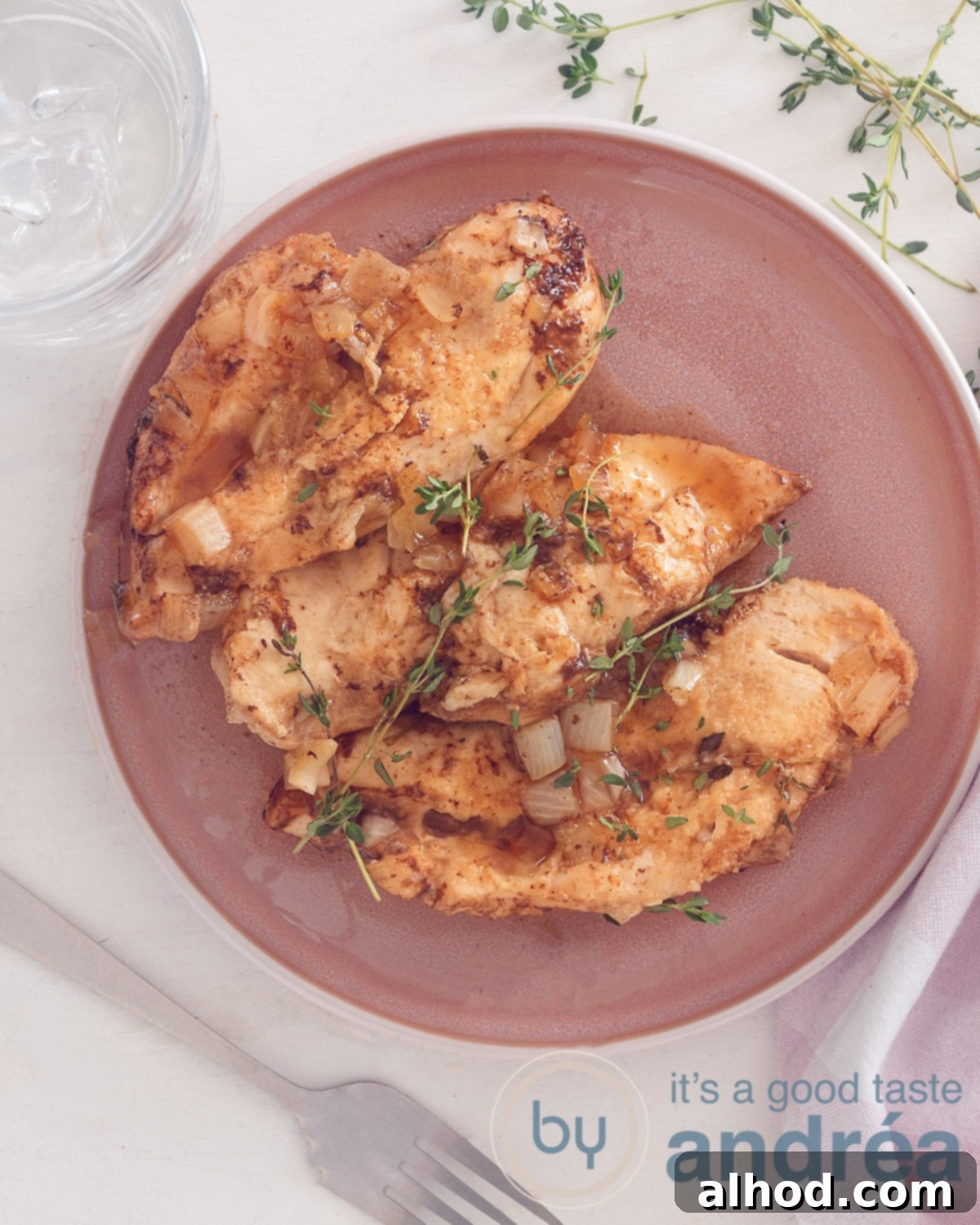 Sticky Slow Cooker Brown Sugar Garlic Chicken 2 A photo from above of a pink plate with three brown sugar chicken breast filet prepared in the slow cooker. A white background.