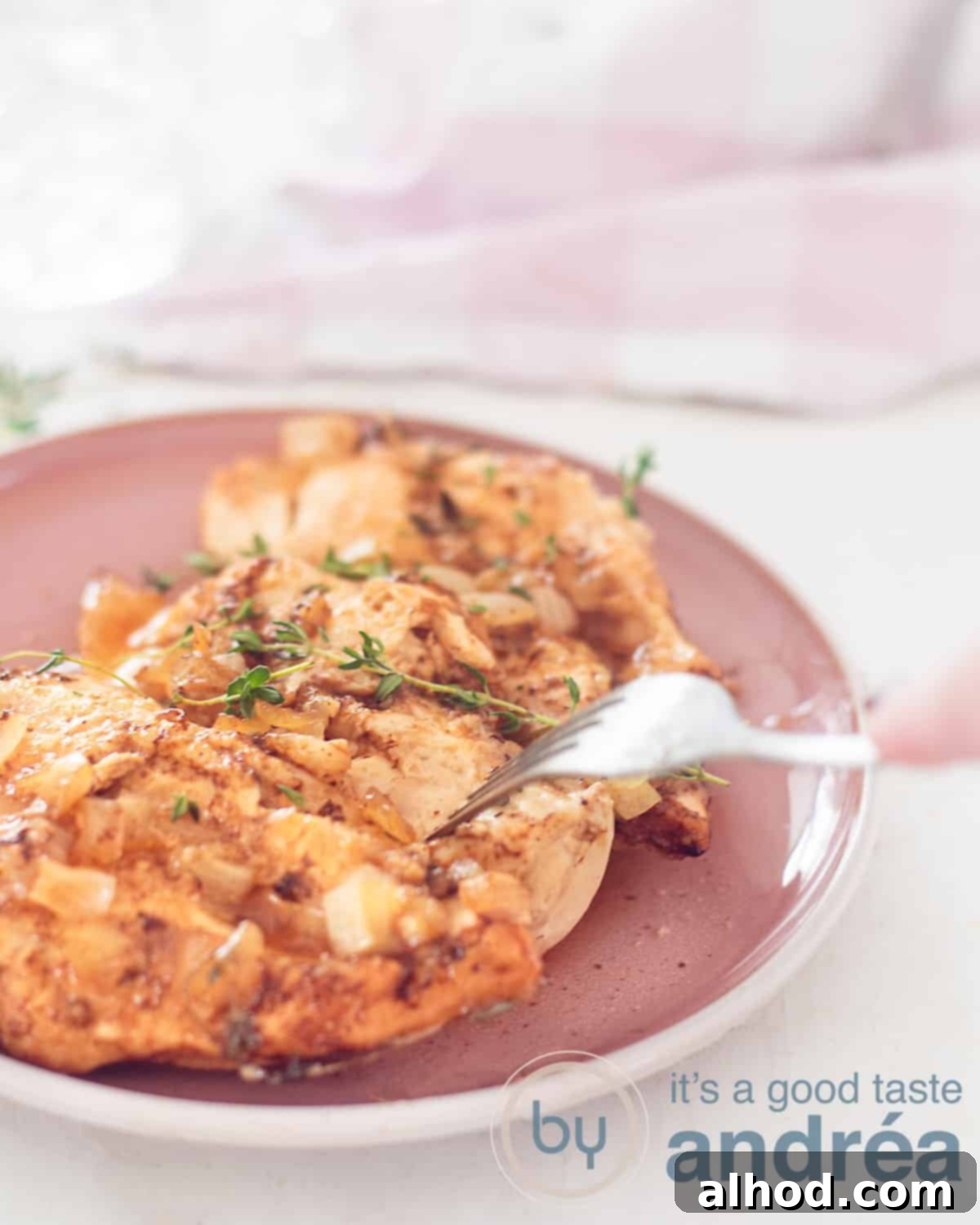 Sticky Slow Cooker Brown Sugar Garlic Chicken 5 An aerial view of a chicken, with a brown sugar marinade and fresh thyme on a pink plate. A white background.