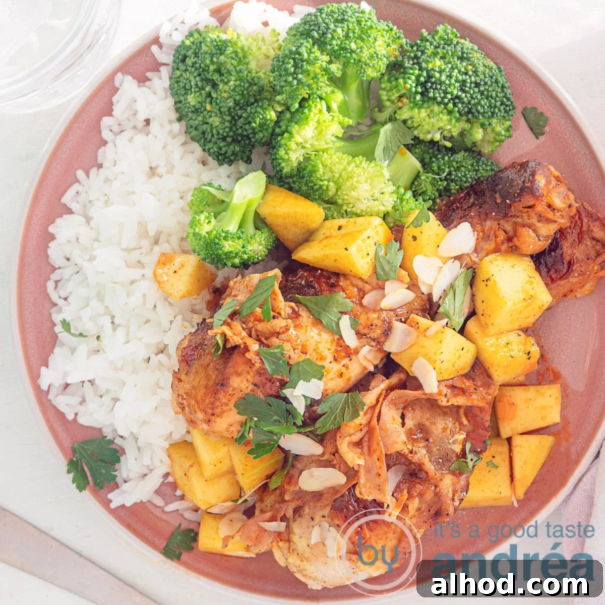 Mango-Glazed Chicken Drumsticks with Bacon 6 A square photo with a pink plate with drumsticks, bacon, mango, sauce, slivered almonds, rice and broccoli