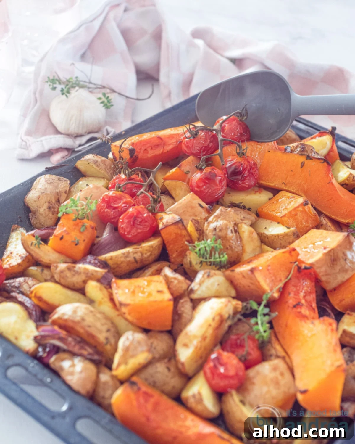 Golden Roasted Pumpkin and Potatoes 2 Part of an oven tray with roasted tomatoes, onion, pumpkin and potatoes. Everything flavored with thyme.