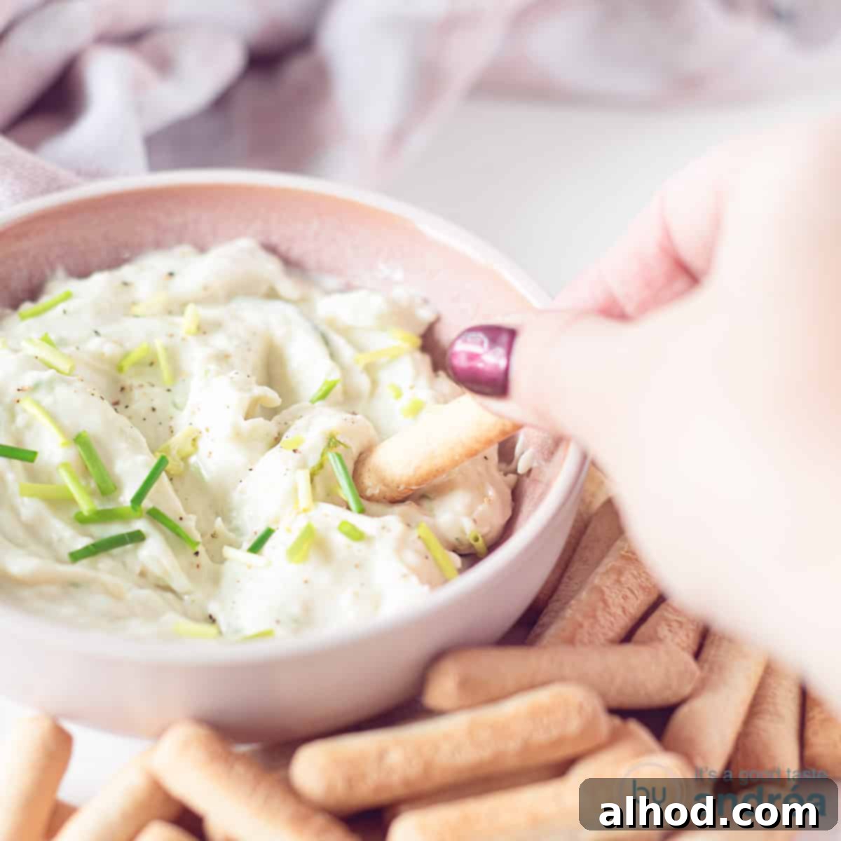 Creamy Gorgonzola Delight 4 A square photo with gorgonzola dip, where a stick takes out a scoop. Sticks lie around it.