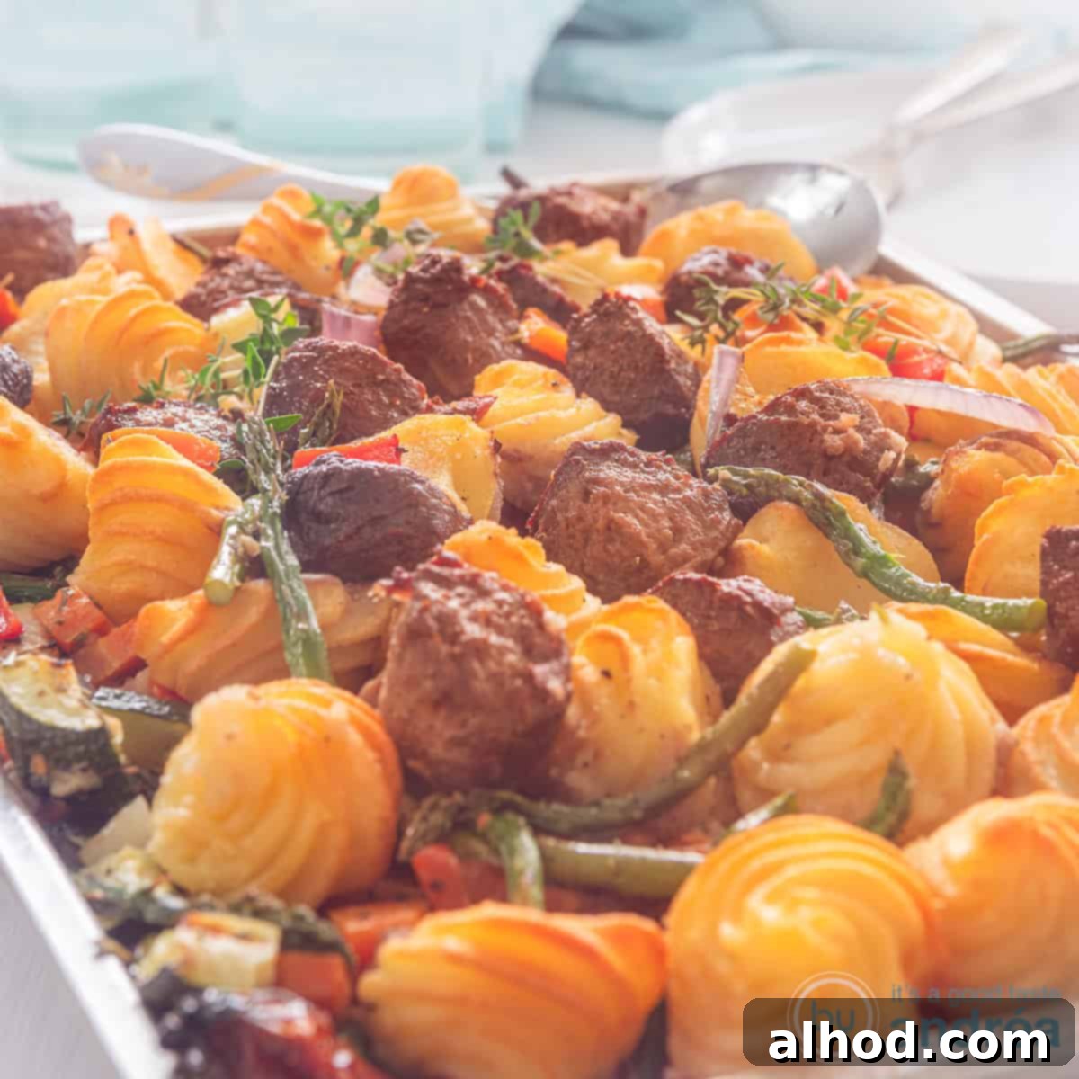 Easy Sheet Pan Burgers with Fluffy Duchess Potatoes 4 A square photo of a baking tray with roasted pommes duchesse, vegetables and burger pieces