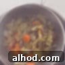 A sieved pot of chicken soup, with a sieve of leftover vegetables on top.