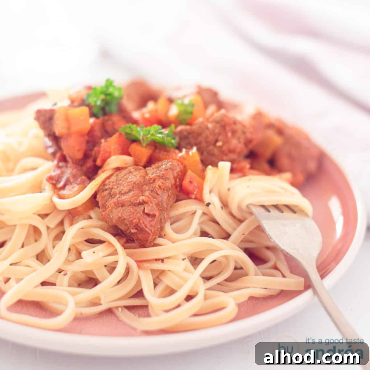 Slow-Simmered Italian Beef Spezzatino 4 A square photo with a pink plate with tagliatelle and Italian stew