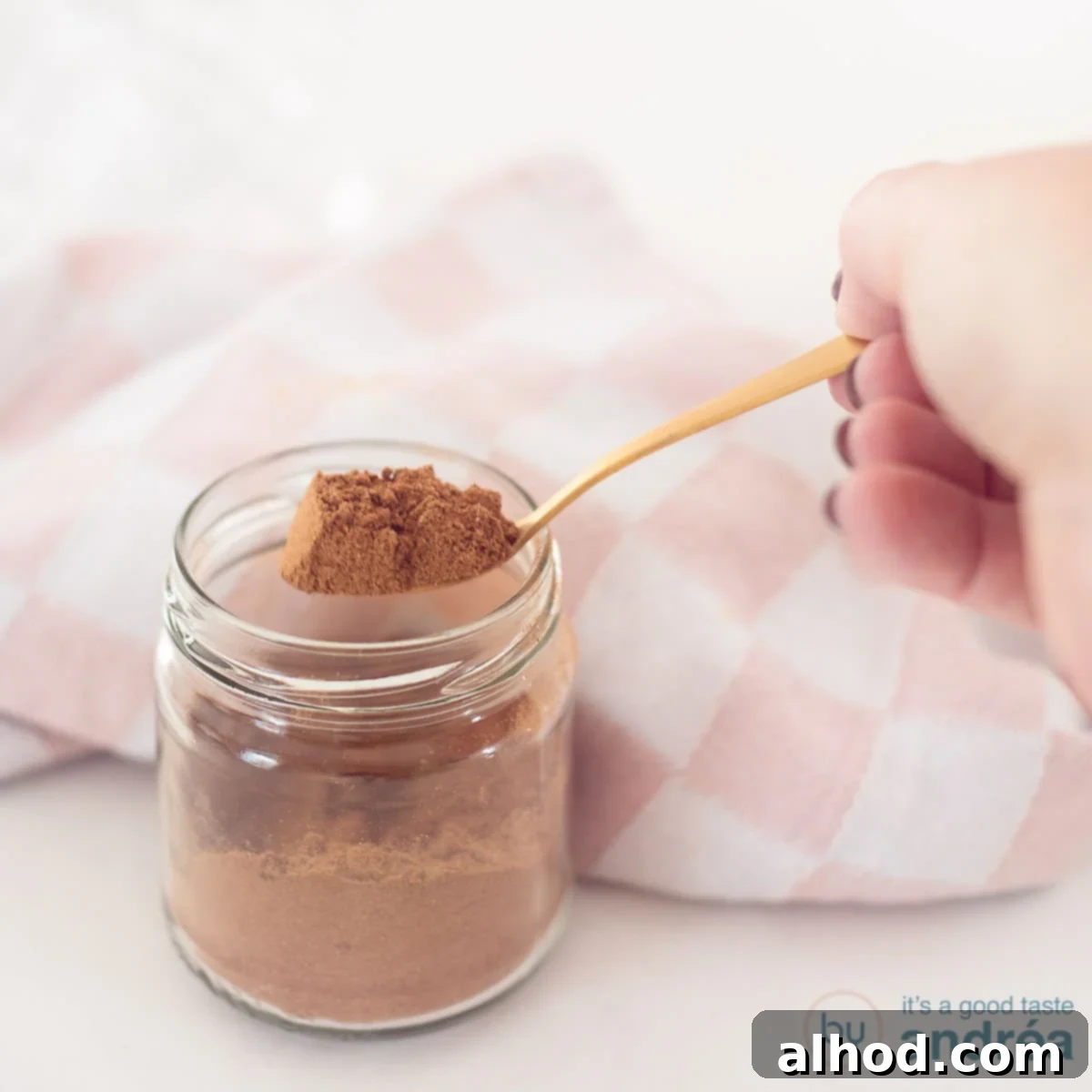 Homemade Dutch Speculaas Spice Blend 4 A square photo with a glass jar with a spoon showing gingerbread spices.