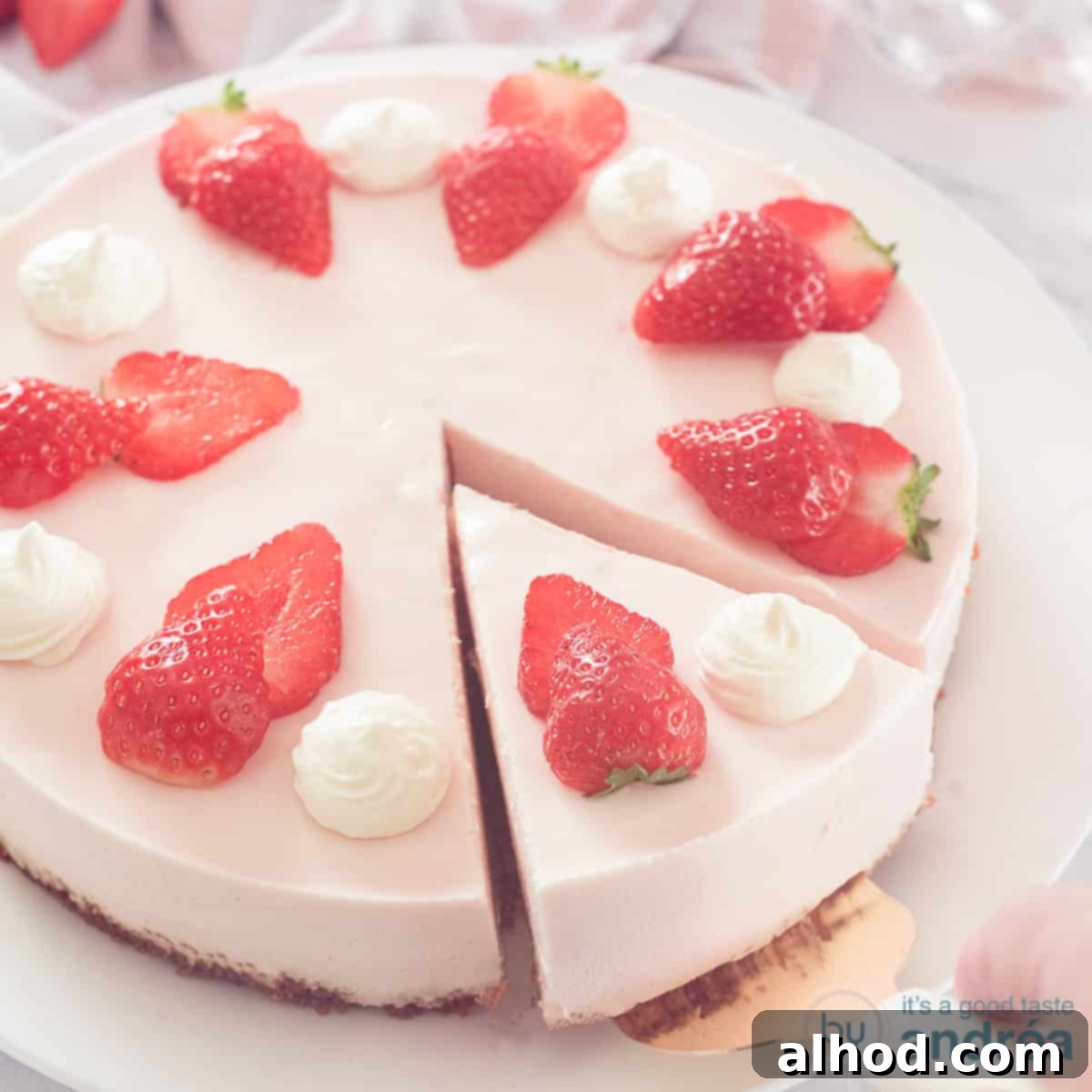 Strawberry Quark Cheesecake 4 A square photo with a strawberry cheesecake with a point cut out. Garnished with fresh strawberries and whipped cream.