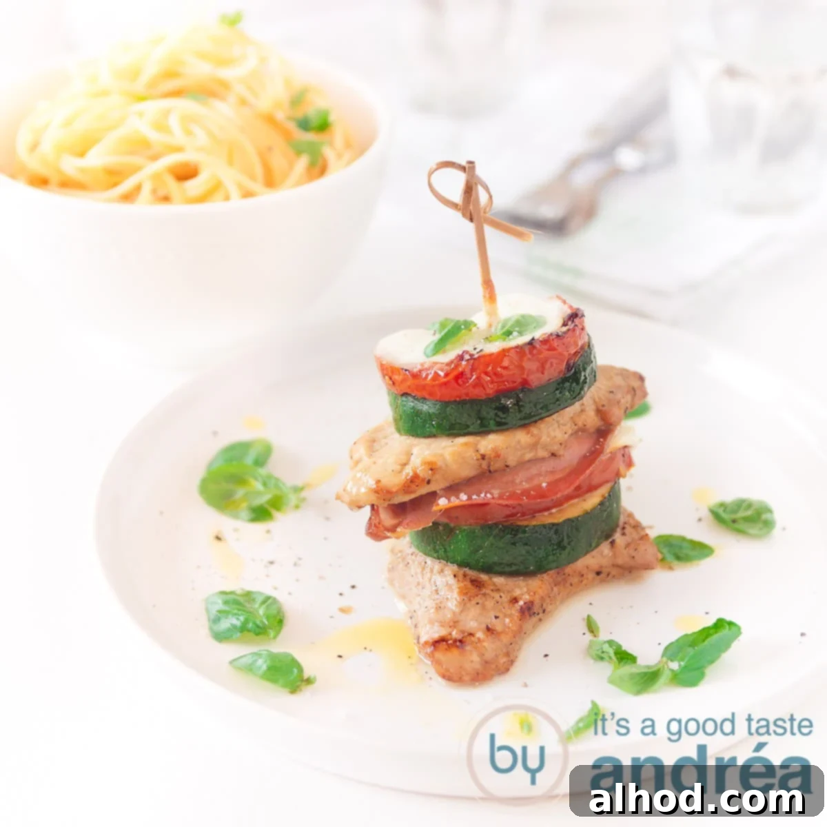 24 Festive Christmas Dinner Recipes 12 A square photo with a plate with open saltimbocca and a bowl of spaghetti in the background