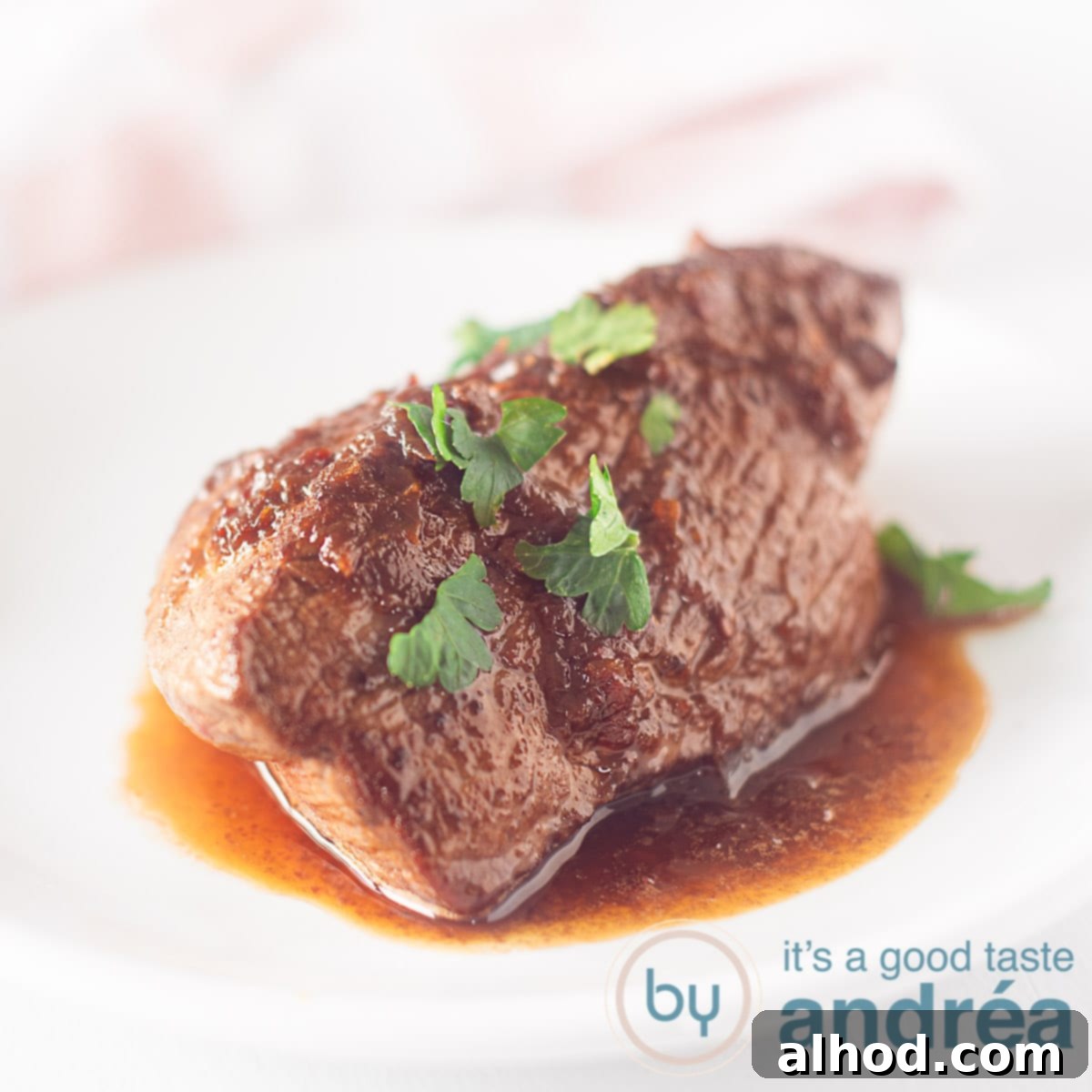 24 Festive Christmas Dinner Recipes 15 A white plate with a steak a la loetje baked on it. A pink and white tea towel in the background