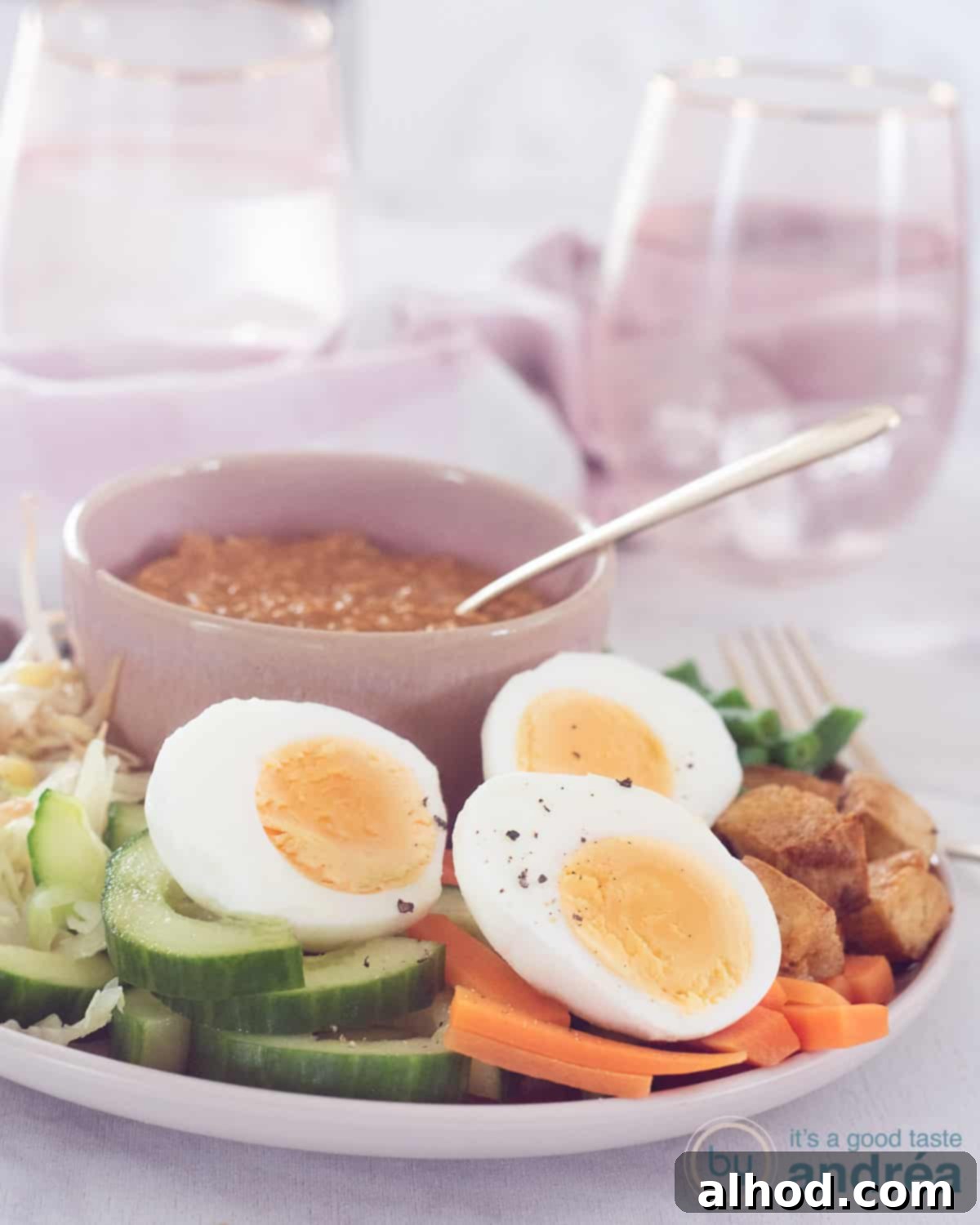Gado Gado with Creamy Peanut Sauce 2 A pink plate with perfectly blanched vegetables, sliced eggs, and golden-fried tofu cubes, accompanied by a small pink bowl of rich satay sauce, ready to be enjoyed.