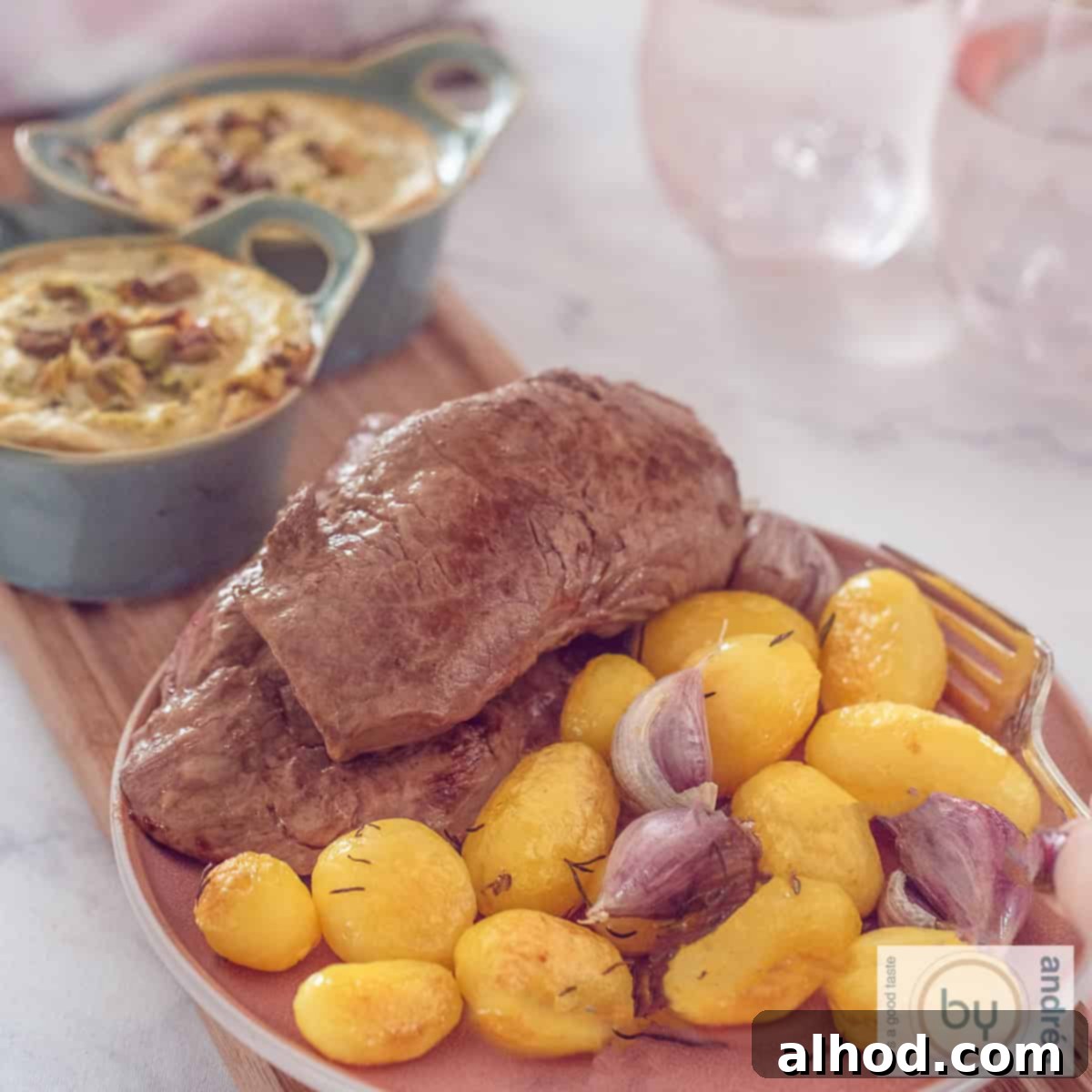 Hearty Rump Steak with Tangy Goat Cheese Broccoli Quiche 4 A square photo with a pink plate with potatoes, roasted garlic and sirloin steak. However, there are two bowls with broccoli goat cheese quiche