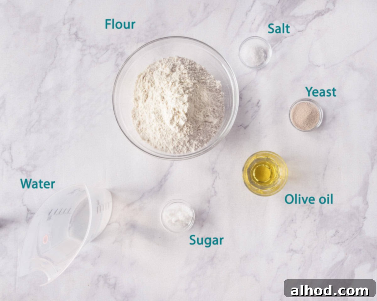 Effortless Homemade Pizza Dough 3 A beautiful flat lay of the simple ingredients needed to make quick and easy pizza dough, arranged on a classic marble background.