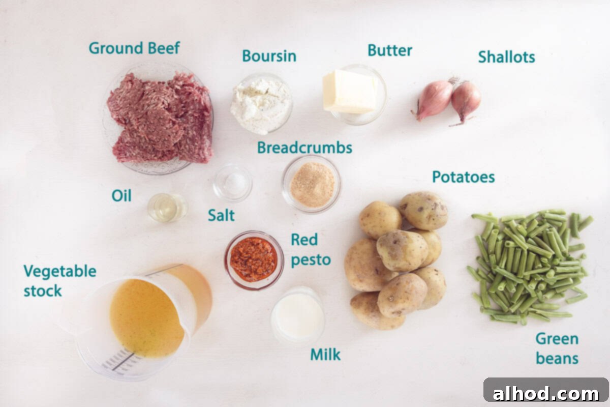 Creamy Boursin Beef and Mashed Potato Casserole 3 Arrangement of fresh ingredients for Boursin Mashed Potato and Beef Casserole, including potatoes, Boursin cheese, ground beef, green beans, shallots, and red pesto on a white background.