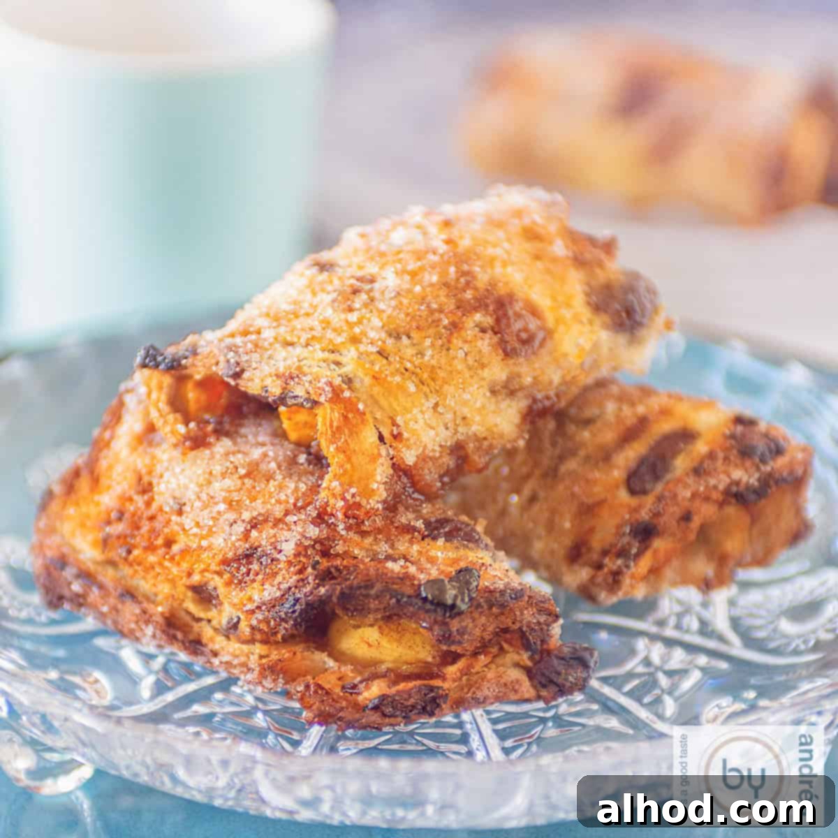 Cinnamon Apple French Toast Roll-Ups 5 A square photo with three apple pie rolls in the middle on a glass plate.