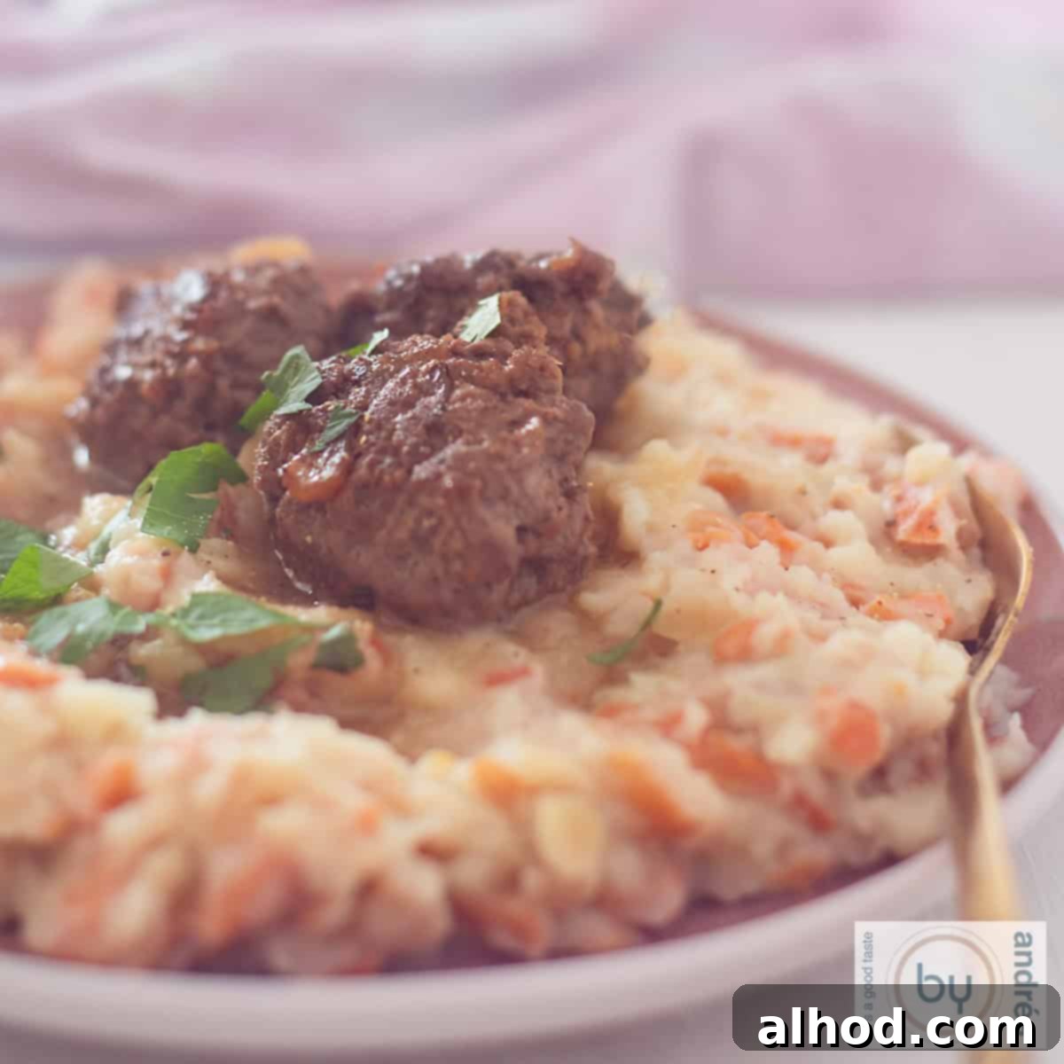 Velvety Dutch Hutspot with Zesty Meatballs 6 A square photo showing part of a plate of wortelstamppot with spicy meatballs.