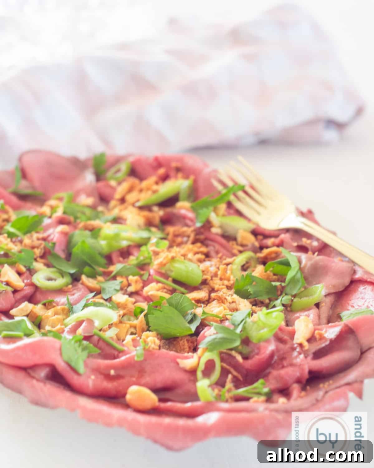 Savory Asian Roast Beef Salad with Irresistible Crunch 2 An aerial photo of a bowl of roast beef salad with spring onion, Asian dressing, cashew nuts and onions