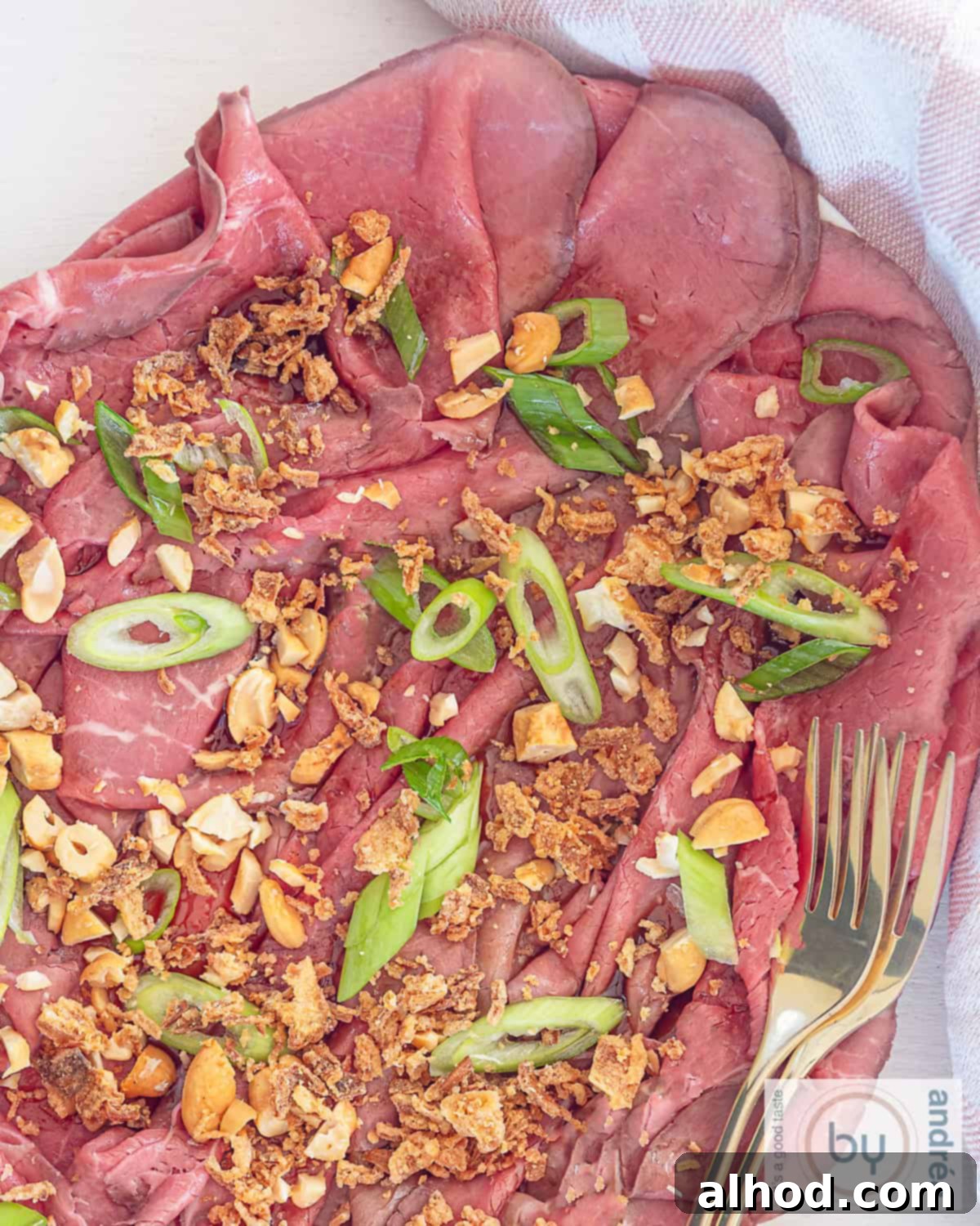 Savory Asian Roast Beef Salad with Irresistible Crunch 5 A top-down photo of a platter of roast beef with Asian-style garnish and dressing in the form of a carpaccio appetizer