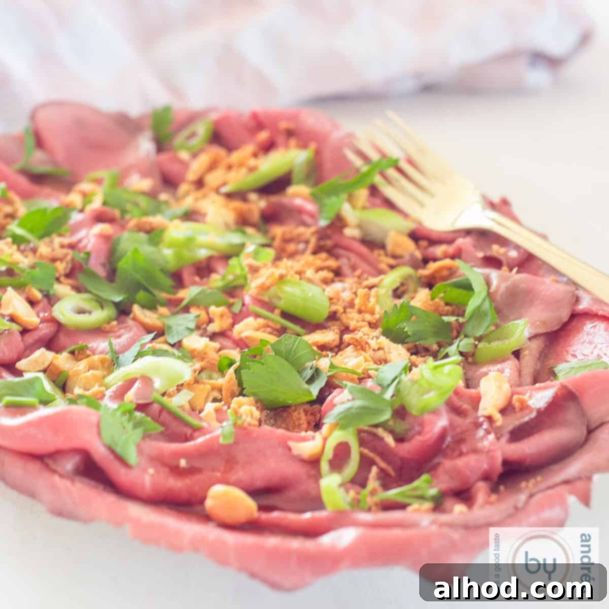 Savory Asian Roast Beef Salad with Irresistible Crunch 6 A square photo with a bowl filled with Asian style roast beef carpaccio salad.