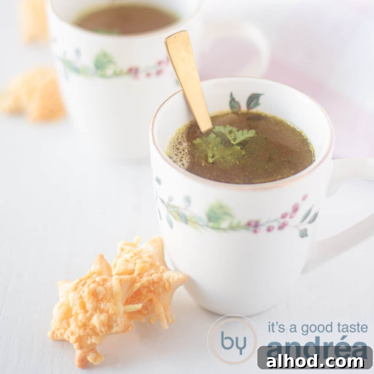 Kids Festive Feast 4 A square photo with a white background, two cups diagonally behind each other. In it a broth. Two cheese stars stand against the first cup.